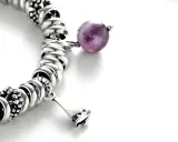 Bracciale con charm e una sfera di ametista, simbolo di pace e spiritualità. L'ametista significato esoterico è noto per la sua capacità di calmare la mente.