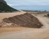 Un terraplén, parte de una obra vial, se eleva con tierra removida. El terraplén significado es la elevación artificial del terreno.