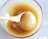 En sked lyfter krämig kolasås ur en skål. Perfekt för ditt kolasås recept!