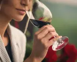 Mujer cata vino tinto, evaluando su aroma. ¿Cuánto cobra un catador de vinos por su experiencia?