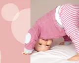 Uśmiechnięte dziecko w różowo-białe paski, kiedy dziecko raczkuje, wywraca się do góry nogami na białym tle.