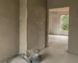 Ściany pokryte tynkami cementowo wapiennymi, przygotowane do dalszych prac. Widać wiadro z zaprawą i narzędzia.