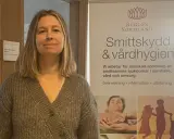 Kvinna framför banderoll om smittskydd och vårdhygien i Region Sörmland. Hon arbetar troligen med tbe kalmar.