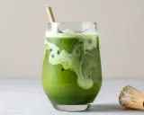 En krämig islatte med virvlande mönster, en bambuvisp bredvid. Matcha nyttigt och gott!