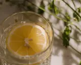 Ett glas med vatten och en citronskiva, perfekt för varma sommardagar. Enkel och uppfriskande bland sommar drinkar.