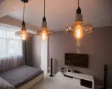 Trzy lampy wiszące z żarówkami Edisona tworzą przytulne oświetlenie bez prądu, idealne do sypialni.