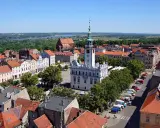 Urokliwy widok na rynek i zabytkowe kamieniczki w kujawsko-pomorskim. W tle rzeka i zieleń.
