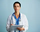 Medico con camice bianco e stetoscopio, appunti su cartella clinica. Ricerca sulla sindrome di Laron.