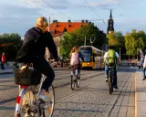 Menschen radeln durch eine Stadt in Deutschland, ein gelber Tram fährt vorbei. Perfekt für Bikepacking Deutschland!