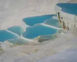 Turkusowe wody spływają po białych tarasach wapiennych. To właśnie tam znajduje się Pamukkale, cud natury w Turcji.
