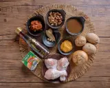Zutaten für ein Massaman Curry Paste Rezept: Hähnchenschenkel, Kokosmilch, Erdnüsse, Kartoffeln, Zwiebel, Fischsauce, Currypaste und Gewürze.