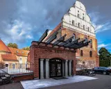 Hotel St. Bruno w Giżycku, dawniej zamek krzyżacki, z charakterystyczną ceglaną fasadą i białym szczytem.