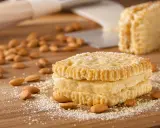 Biscuits Joconde, parfaits pour le goûter, préparés avec le Thermomix. Amandes et sucre glace parsèment la planche en bois.