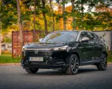 Elegancki, czarny Honda HR-V 2025 na tle jesiennych drzew i kontenerów.