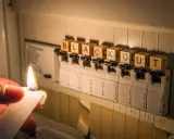Płonąca świeca obok bezpieczników z literami układającymi się w słowo "blackout".