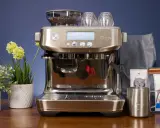 Sage Barista Pro: Perfekter Espresso dank einstellbarer Durchlaufzeit. Kaffeebohnen, Tassen und Milchkanne bereit für den Genuss.