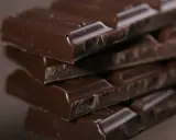 Gestapelte dunkle Schokoladenriegel, die köstlich und e471 vegan aussehen.