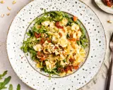 Ein köstlicher mediterraner Salat mit Farfalle, getrockneten Tomaten, Rucola und Pinienkernen.