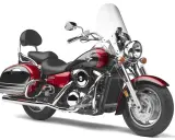 Czerwony motocykl Kawasaki VN 1600 z sakwami i dużą szybą. Choć piękny, jego wady mogą dotyczyć wygody pasażera.