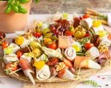 Bunte Platte mit Fingerfood-Dips: Prosciutto-Röllchen, Käse, Trauben, Tomaten, Physalis und Nüsse. Perfekt für jede Party!