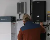 Tekniker kopplar in en ferroamp växelriktare bredvid ett Pylontech batteri.