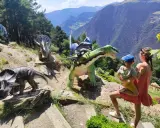 Una familia disfruta de un día prehistórico con dinosaurios en Andorra con niños. Las montañas de fondo crean un paisaje espectacular.