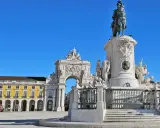 Reiterdenkmal und Triumphbogen am Praça do Comércio in **Baixa Lissabon** unter strahlend blauem Himmel.
