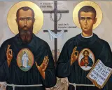 Ikona przedstawia św. Maksymiliana Kolbe i Sługę Bożego Wenantego Katarzyńca. Na piersiach mają medaliony z Matką Bożą i Jezusem.