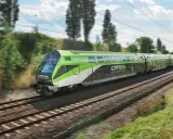 Grön och vit CAT City Airport Train susar fram på spåret, på väg till flygplatsen i Wien.