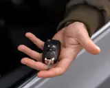 Mano sosteniendo una llave de coche moderna, lista para codificar y arrancar.