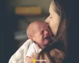 Matka tuli niemowlę, które płacze z powodu bulgotania w brzuchu i bolesnych gazów.