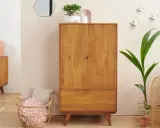 Un buffet haut en bois de chêne, avec un tiroir et deux portes, orné de plantes et d'objets décoratifs.