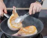Zwei saftige Koteletts braten in der Pfanne. Perfekt für leckere Kotelett Rezepte.
