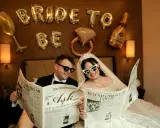 Para młoda czyta gazetę "The Wedding Post" z nagłówkami "Miłość" i "Wszystkie przygotowania zakończone!". Ile pieśni na ślub? Tego nie wiemy, ale na pewno będzie pięknie!