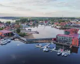 Nowoczesna marina i hotel na Mazurach. Widać tu liczne łodzie, nowoczesną architekturę i malowniczy krajobraz, idealne mazury atrakcje.