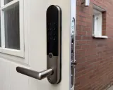 Ett modernt Yale Doorman V2N-lås på en vit dörr, redo att styras via app.