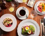 En härlig frukost i Stockholm med en smoothie bowl, avokadotoast, frukt och kaffe.