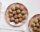 Plato con trufas de chocolate espolvoreadas con cacao y otras cubiertas de frutos secos.