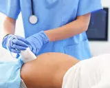Lekarz wykonuje badanie ultrasonograficzne brzucha ciężarnej. Dowiedz się, co to jest ultrasonografia i jak pomaga w diagnostyce.