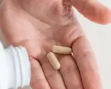 Dwie kapsułki probiotyku na dłoni, gotowe do zażycia przed wyjazdem do Turcji.