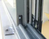 Detalle de cómo hacer una mosquitera corredera: el marco de aluminio y la malla en un riel.