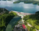 Majestatyczna solina zapora w otoczeniu zielonych wzgórz i błękitnej wody jeziora. Widok z lotu ptaka ukazuje potęgę natury i ludzkiej inżynierii.