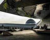 Nowoczesna architektura i ludzie odpoczywający pod zadaszeniem. W tle kopuła Muzeum Śląskiego, jedna z głównych katowice atrakcje.