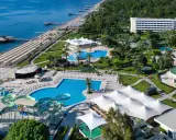 Widok z lotu ptaka na Mirage Park Resort: plaża, baseny, zjeżdżalnie wodne, białe pawilony i hotele otoczone zielenią.
