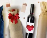 Elegancka dekoracja butelki z winem na ślub. Wino w ozdobnym woreczku z juty, butelka z etykietą "Wino dla Ciebie" i butelka owinięta w papier.