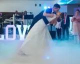 Para młoda tańczy do muzyki na weselu, otoczona mgłą i literami "LOVE". To jak scena z najsłynniejszych baletów.