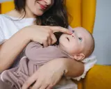 Mama delikatnie dotyka noska dziecka, które ma katar przy ząbkowaniu.