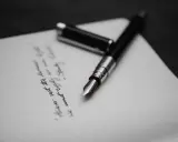 Pióro wieczne na papierze, gdzie widnieje fragment tekstu, być może ostatnia wola lub testament.