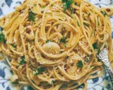 Pyszne spaghetti aglio olio z czosnkiem, natką pietruszki i płatkami chili, posypane parmezanem.