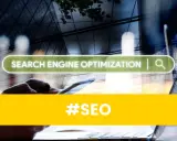 Ręce trzymające smartfon, na ekranie pasek wyszukiwania "SEARCH ENGINE OPTIMIZATION". #SEO to klucz do samodzielnego pozycjonowania.